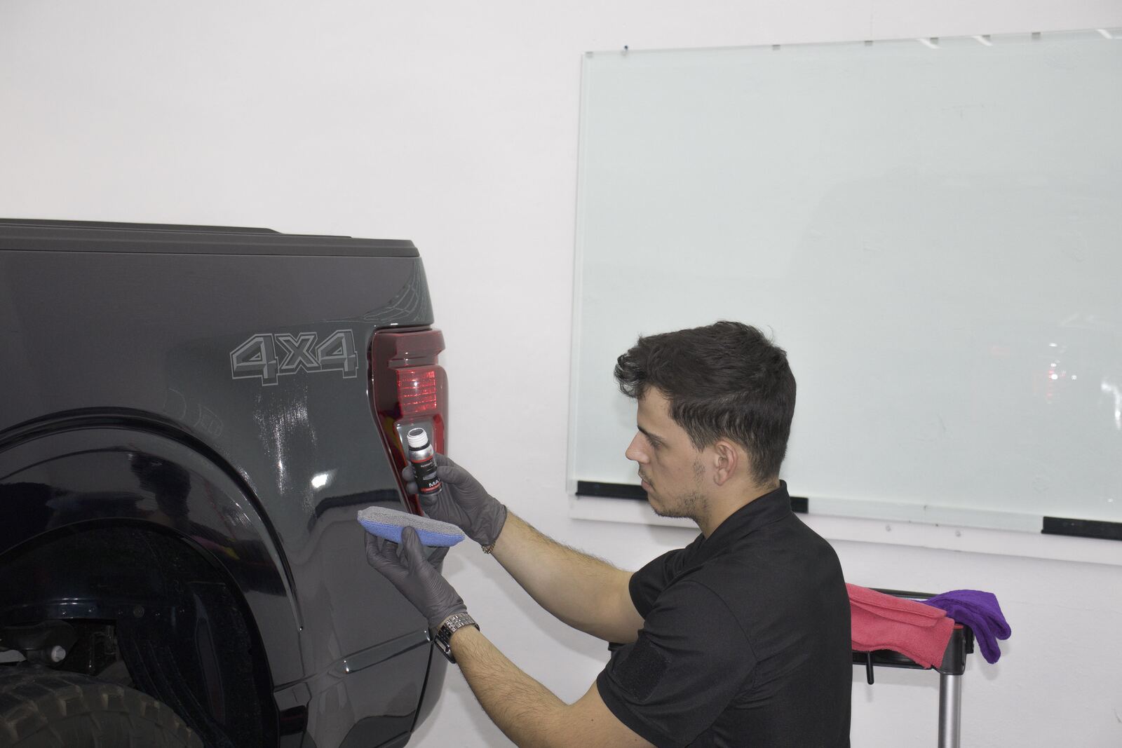Technician machine polishing a truck before ceramic coating