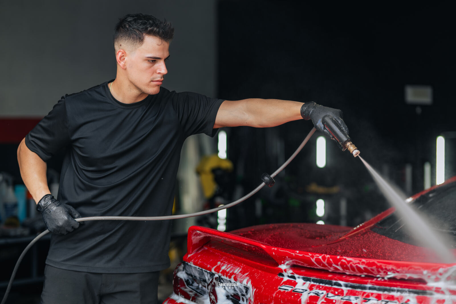 Technician foam-washing a red car